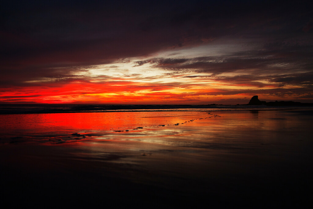 Sunset over the iconic Shark’s Fin rock at Playa Maderas